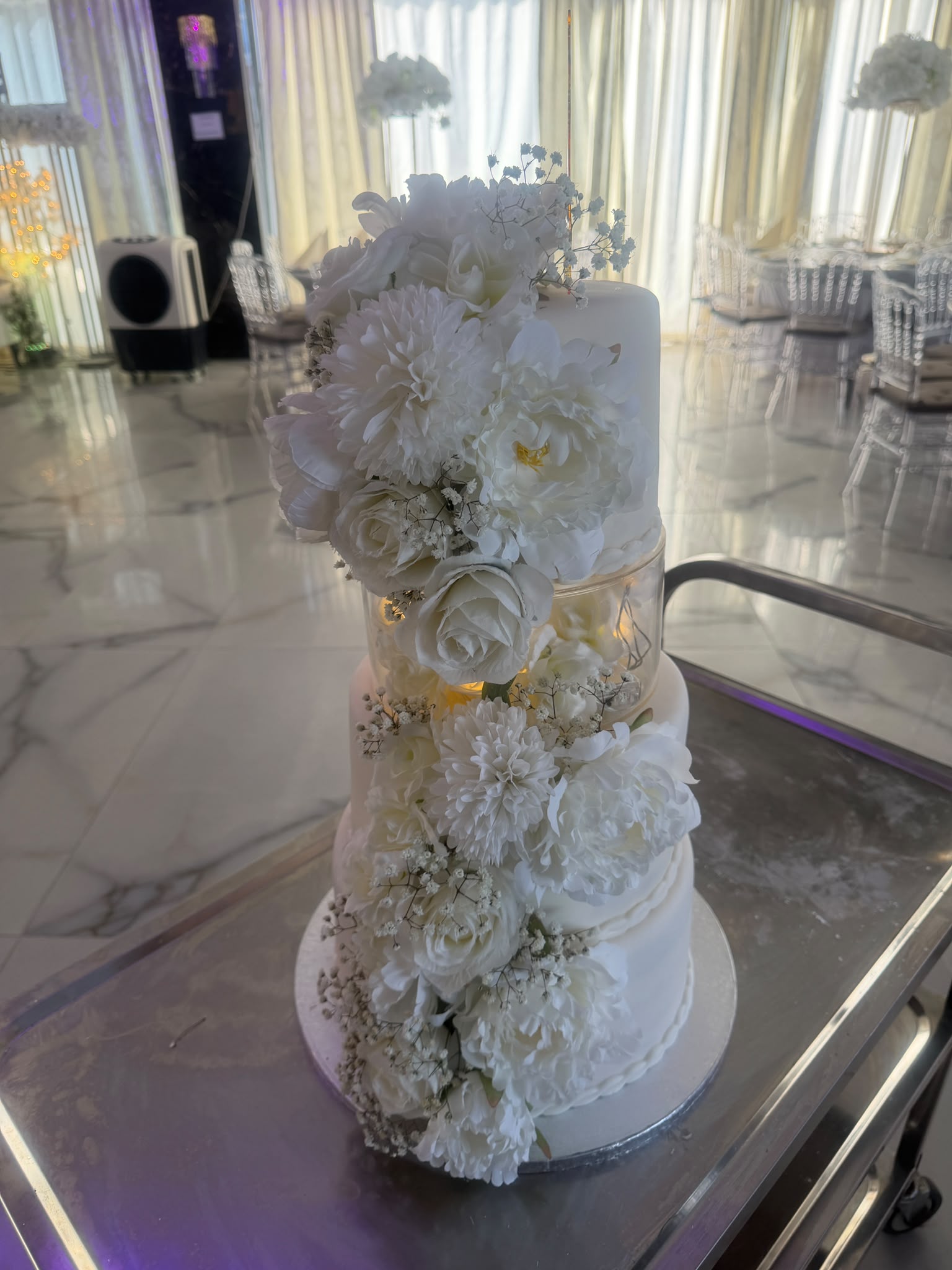 Mehrstöckige Hochzeitstorte mit weißen Blumen